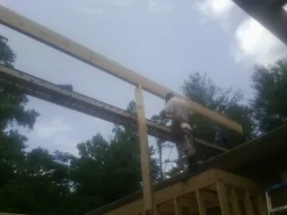Carpenter setting a ridge beam over a new addition frame — Ice Dam Removal by Roofing Brothers in San Jacinto