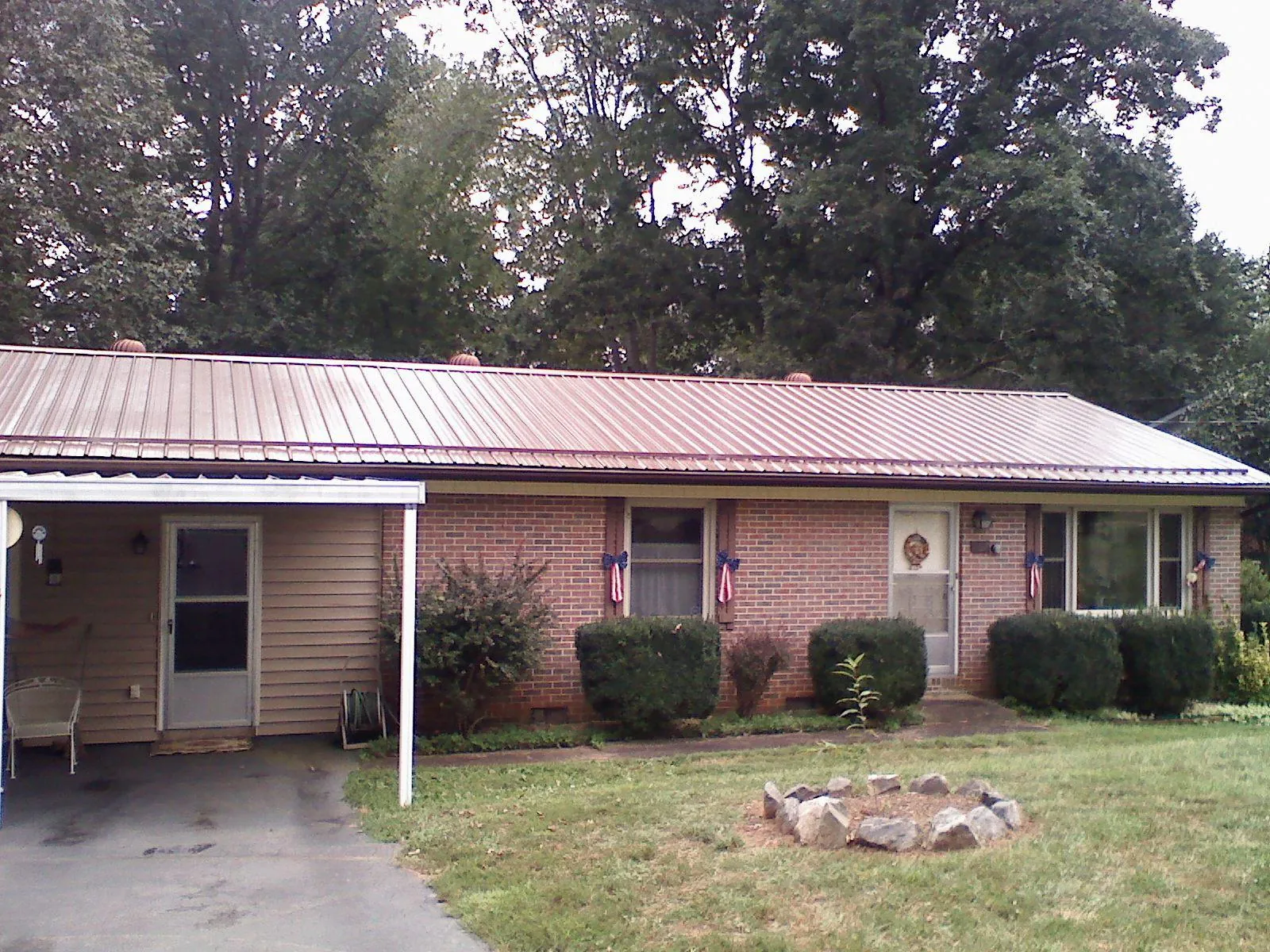 Bronze metal roof and carport on a brick ranch home — Roof Repair work by our crew in San Jacinto