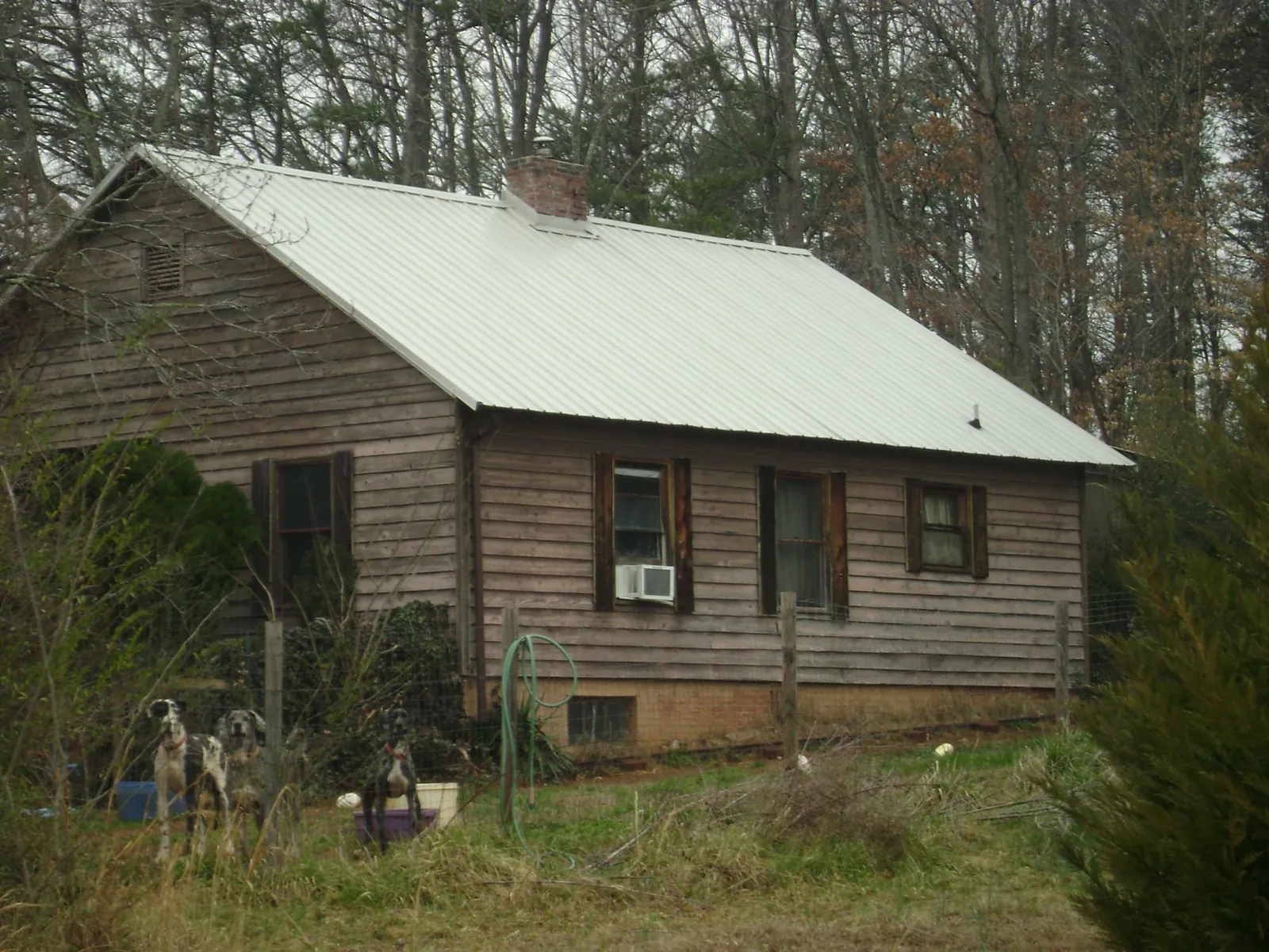 White metal roof on an old wood sided farmhouse, from a Metal Roof Installation job in San Jacinto